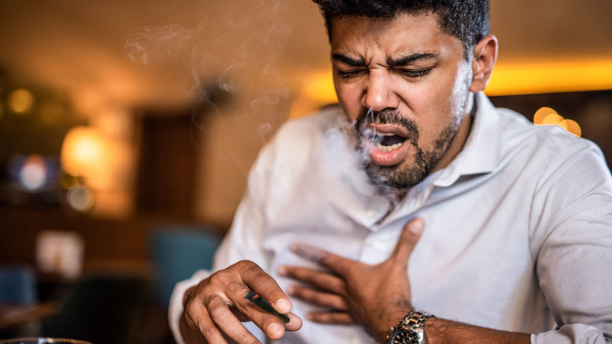 A man coughing after smoking a blunt