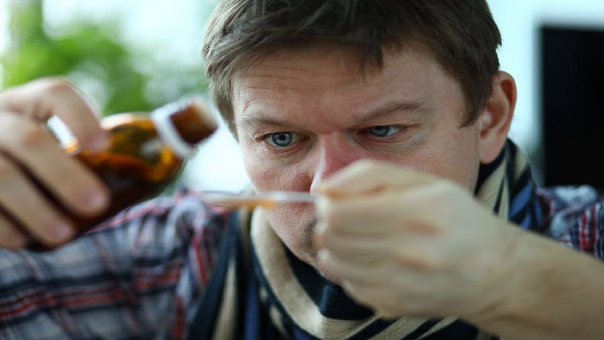 A man pouring THC syrup on a spoon