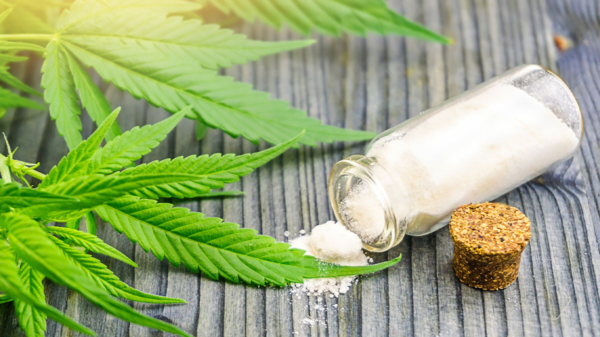 Cannabis leaves and powdered marijuana called canna bumps in a glass bottle
