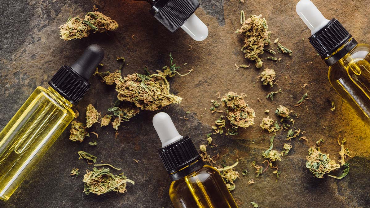 Marijuana buds and bottles with droppers on a wooden table