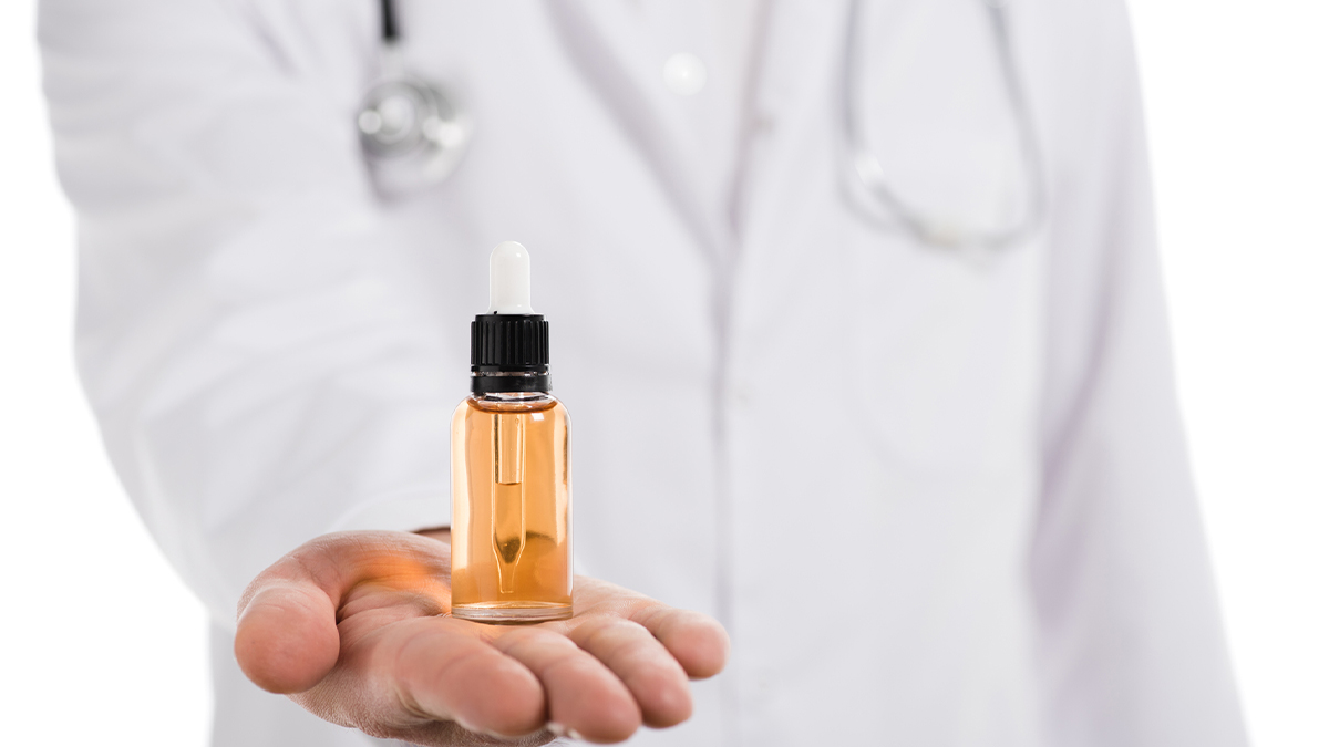 A male doctor with a CBD oil bottle on hand