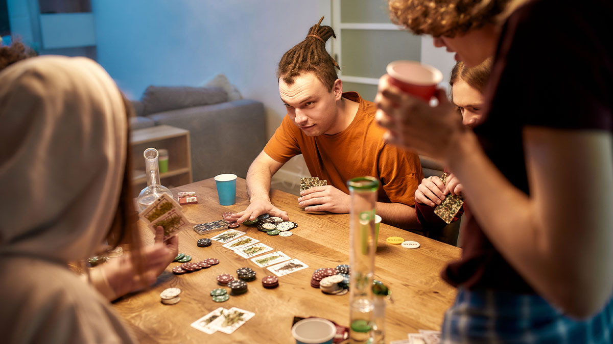 Friends smoking weed and playing poker game.