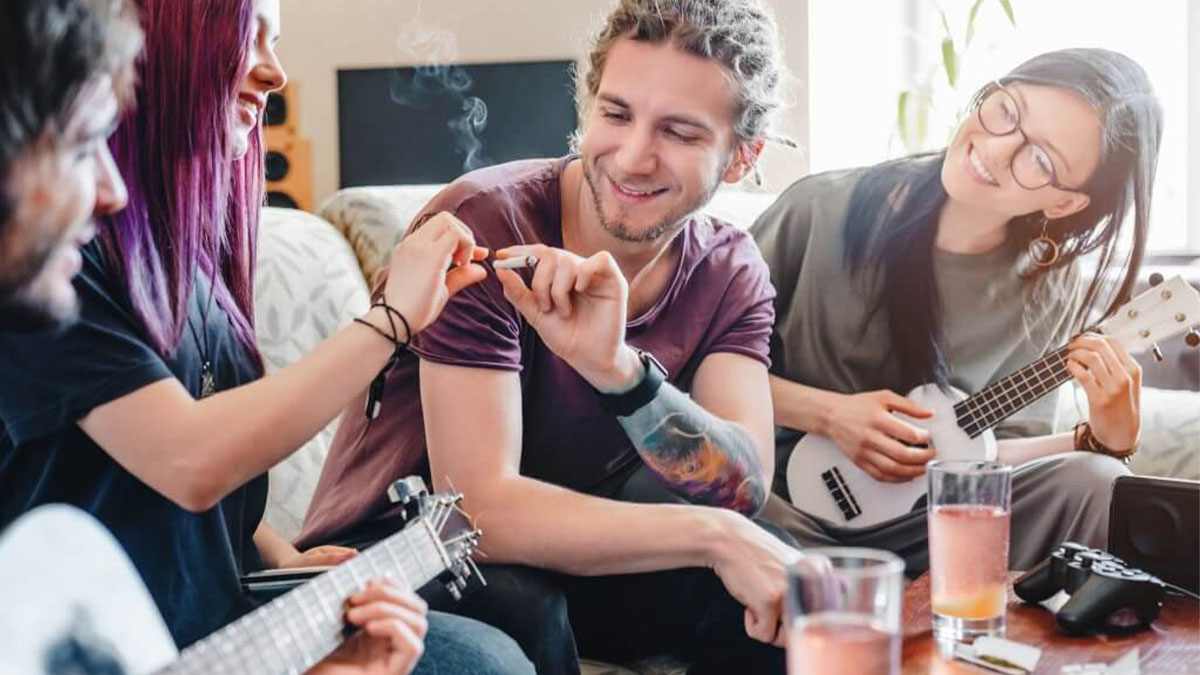 Group of friends playing guitar while high on marijuana.