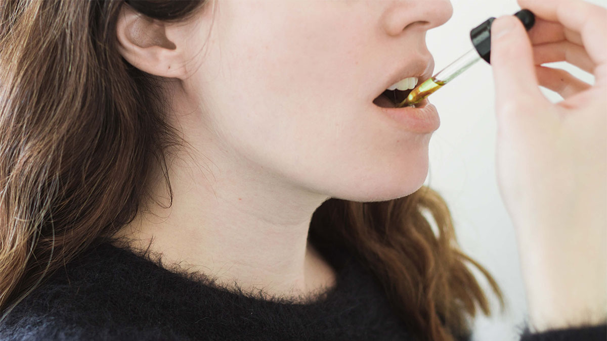 Image of a woman taking Hemp tincture